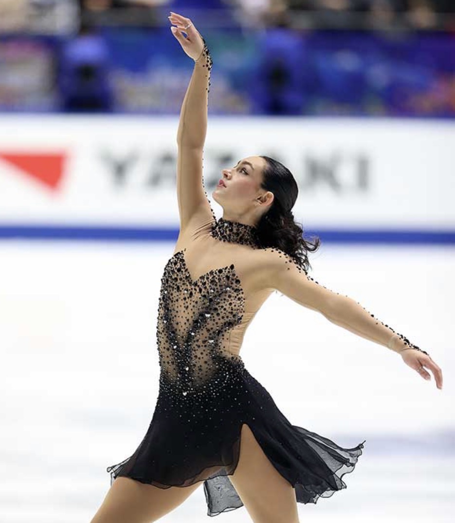Ava Ziegler extending upward during her performance in a black costume